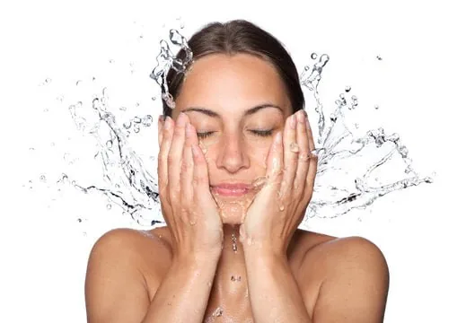 Woman splashing water on face